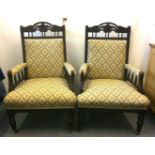 A pair of late Victorian stained walnut armchairs, padded backs and armrests with floral diamond