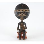 An Ashanti African tribal figure of mother with child sat upon a stool, height 51.5 cm