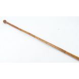 A tribal bamboo stick possibly Indian, with metal tip, carved with extensive decoration, length