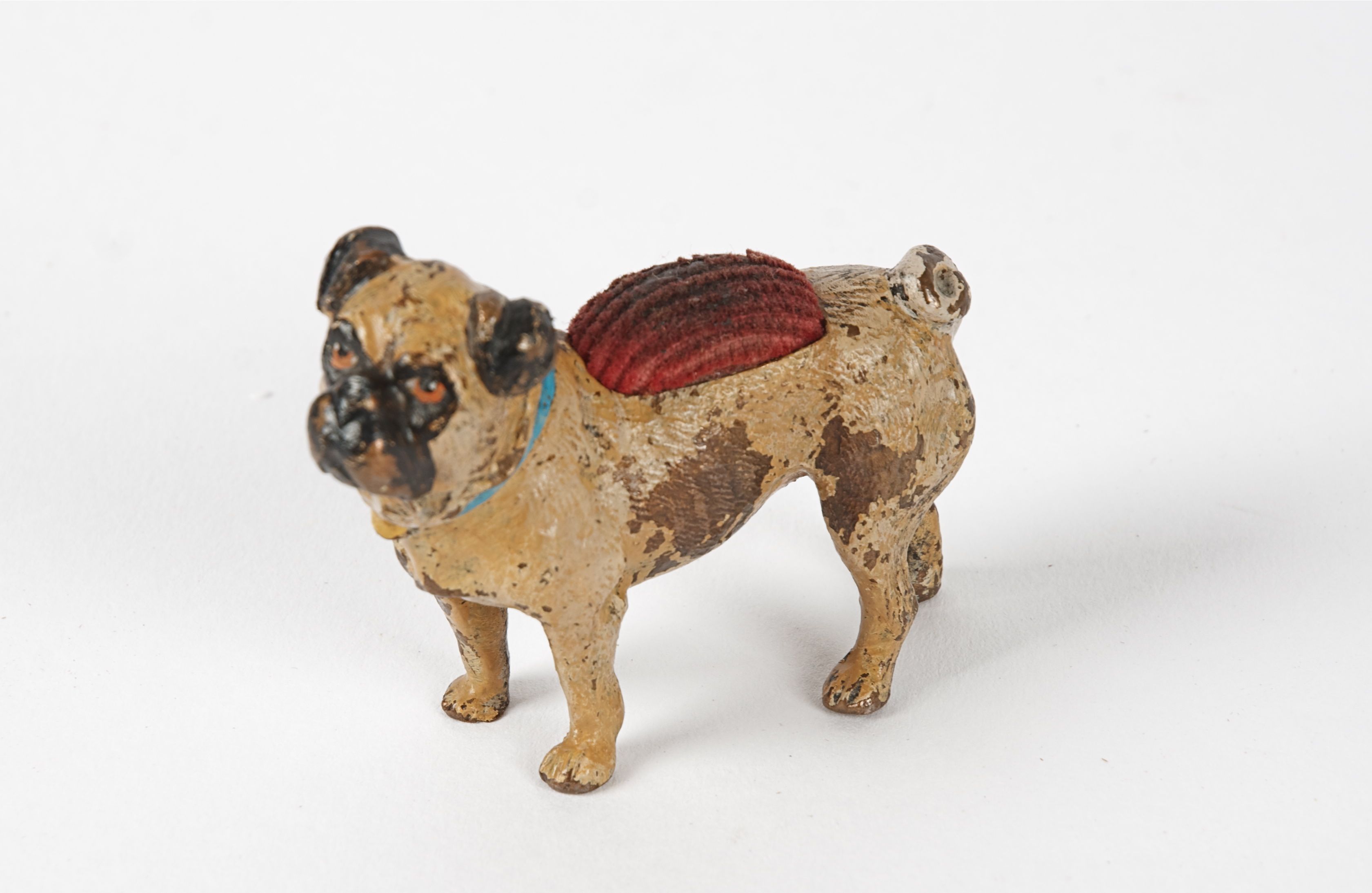 An antique German or Austrian cold painted bronze, taking the form of a pug dog, the base with the