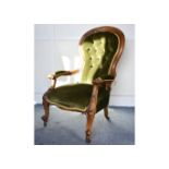 A Victorian walnut button back armchair, with scroll arms and legs, with brass castors and green