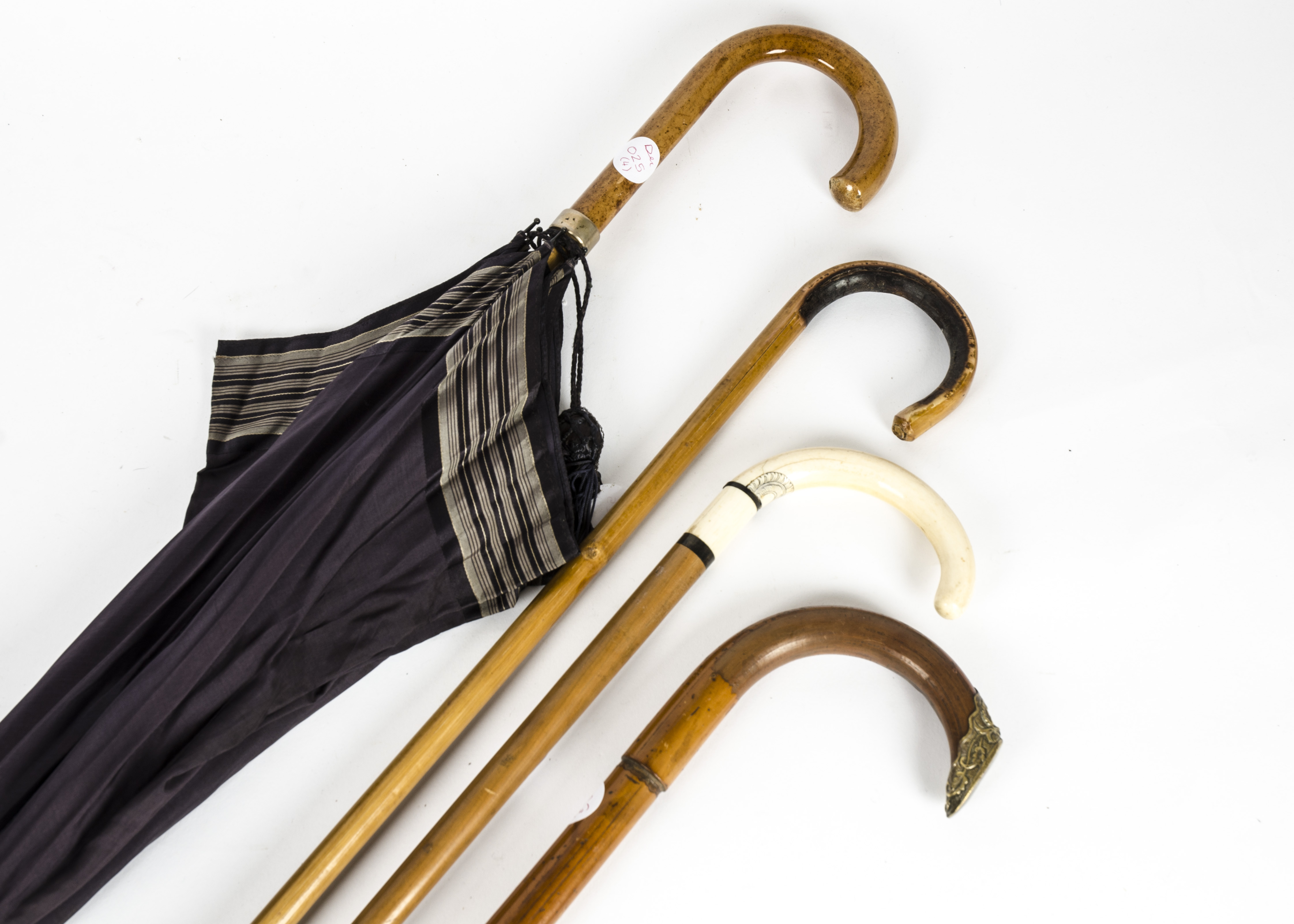 Three 20th Century wooden walking sticks, one with a bone handle, together with a black umbrella