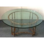 A contemporary circular glass topped coffee table, with a gilt faux bamboo metalwork frame, 107cm