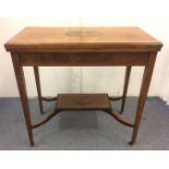 An Edwardian inlaid rosewood card table, swivel lift-up top with a central inlay featuring an oval