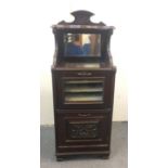 A late Victorian mahogany music cabinet, with mirrored back, two drop down front panels; one