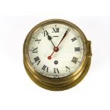 A brass cased ship clock, the circular dial set with Roman numerals, clockwork mechanism,