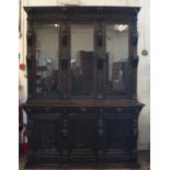 A Victorian continental carved oak two part bookcase, with three glazed doors (key present) and