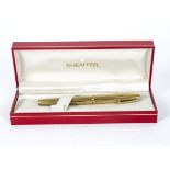 A 1970's Sheaffer fountain pen, with an inlaid nib and gold electroplated case with a ridged design,
