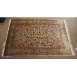 A 20th Century Persian silk rug, a central medallion containing floral springs, upon a beige ground,