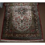 A 20th Century Persian silk rug, a central medallion upon a grey floral ground, worked in black,