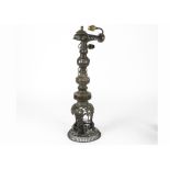 A large late 19th Century Middle Eastern bronze lamp stand, with pierced and moulded scrollwork