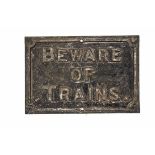 A cast iron 'Beware of Trains' Sign, paint work worn, 23" wide, 15" high, F-G