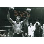FRANK BRUNO Autographed b/w 12 x 8 photo, showing an image of Bruno, arms aloft in celebration,