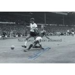 JACK CHARLTON B/W 12 x 8 photo, showing England's Jack Charlton getting to the ball ahead of a