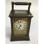 A brass carriage clock with giltwork dial