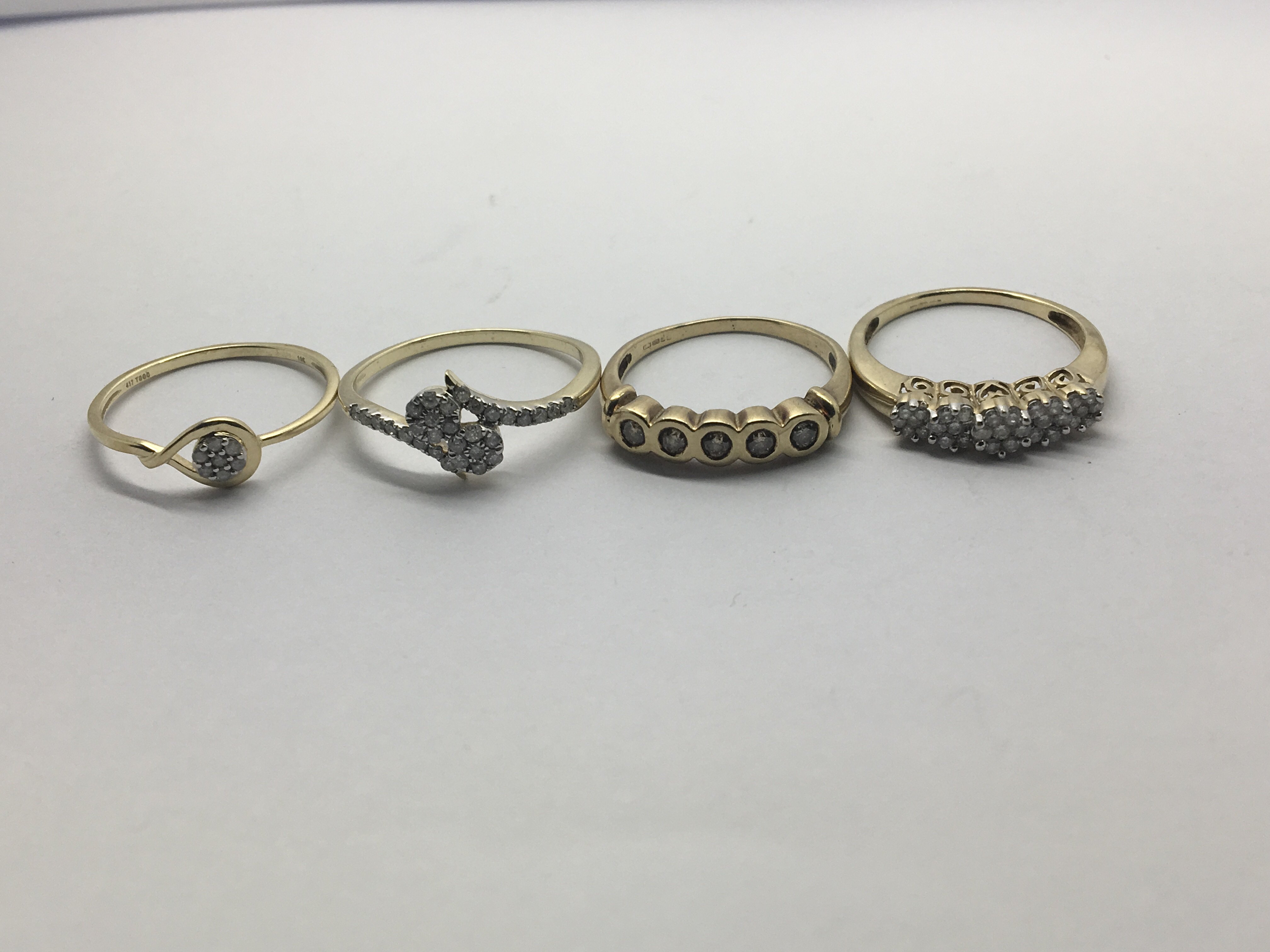 Four 9ct gold rings set with clusters of small dia