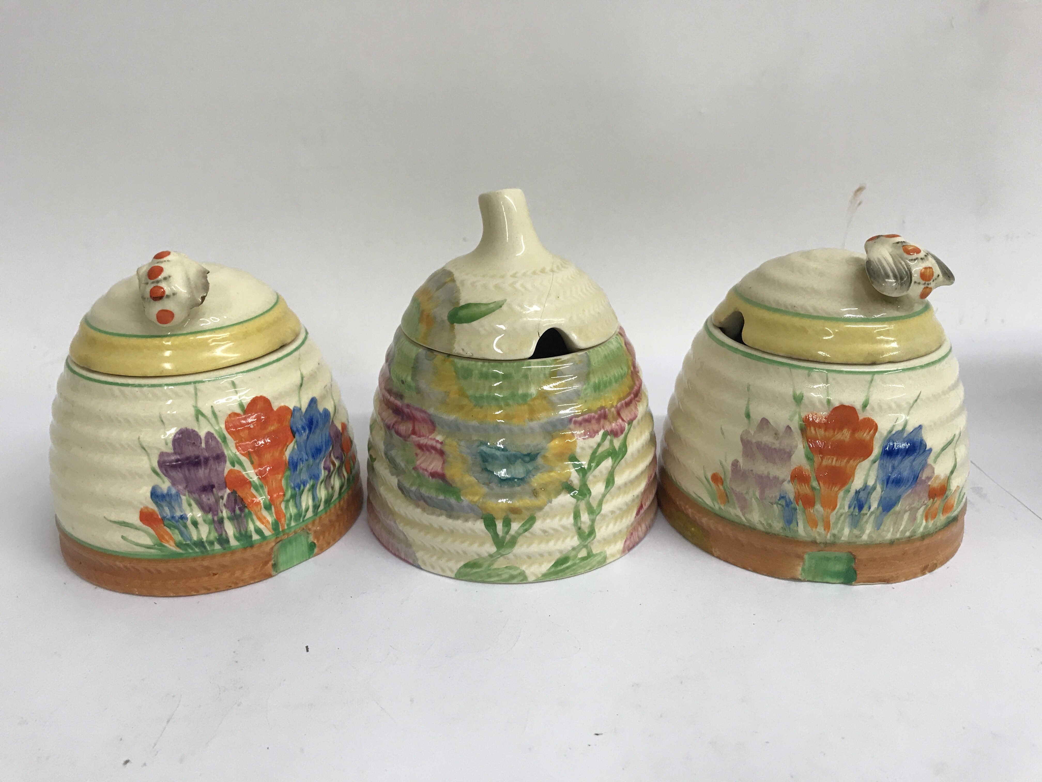 Three Clarice cliff preserve jar and covers , all with faults