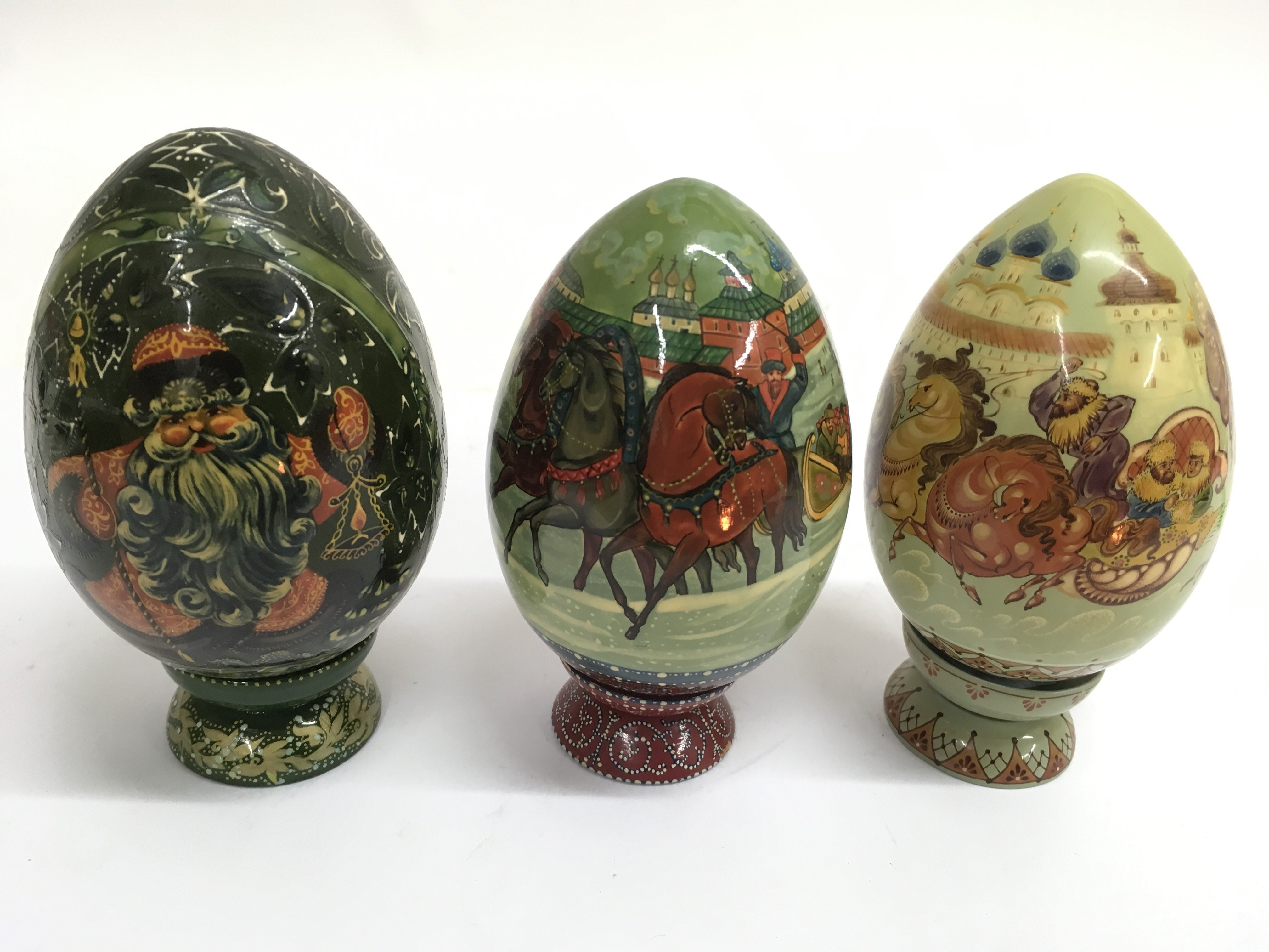 Three finely painted wooden Easter eggs, two paint