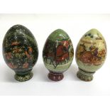 Three finely painted wooden Easter eggs, two paint
