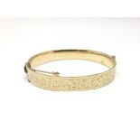 A bronze core gold plated bangle with floral decor