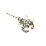 A 9ct gold scorpion brooch inset with blue and whi