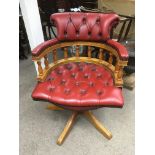 A red leather button back office chair.