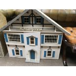 A large dolls house with blue doors and windows co