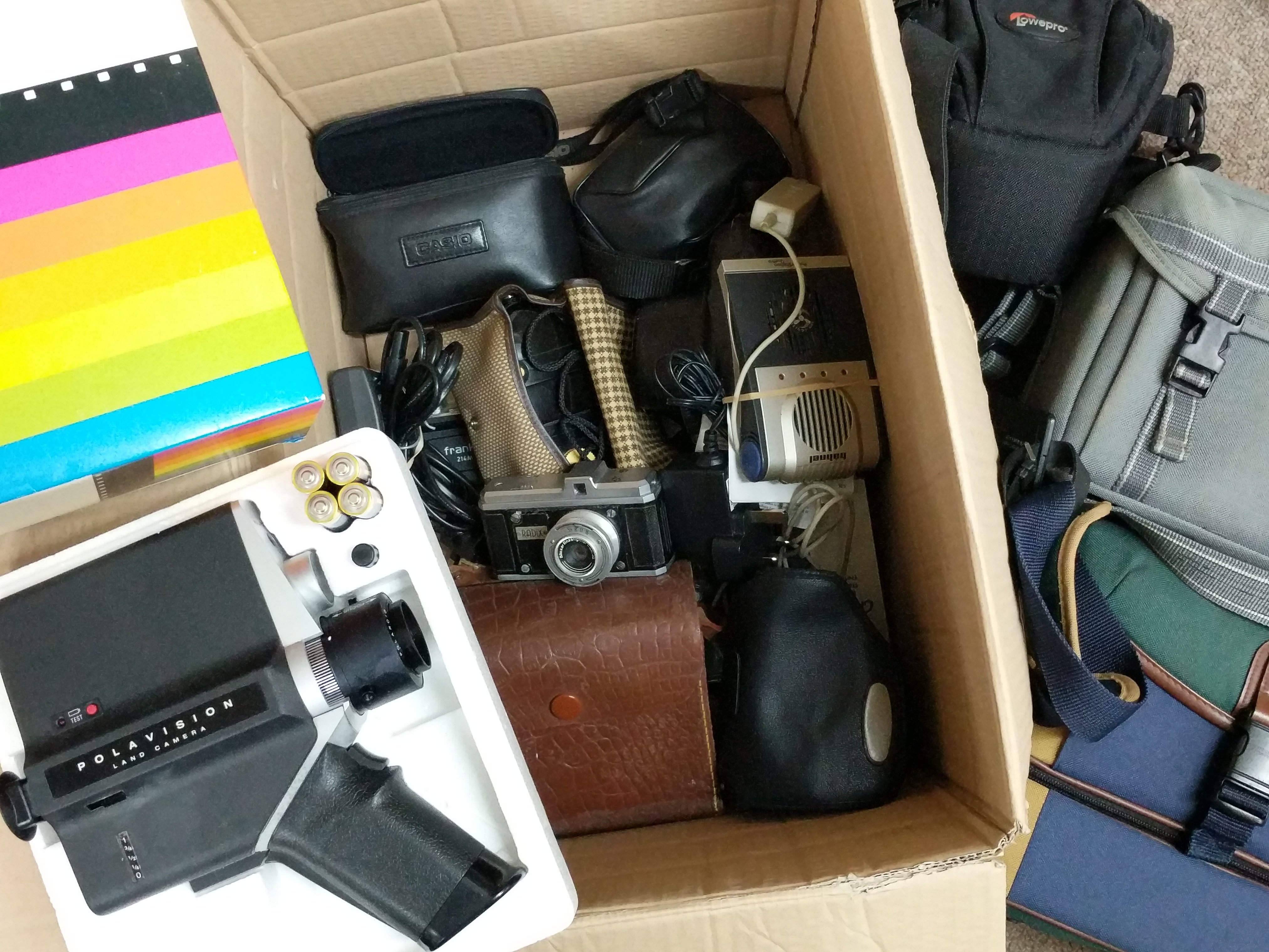 A box of cameras and accessories plus a boxed Pola