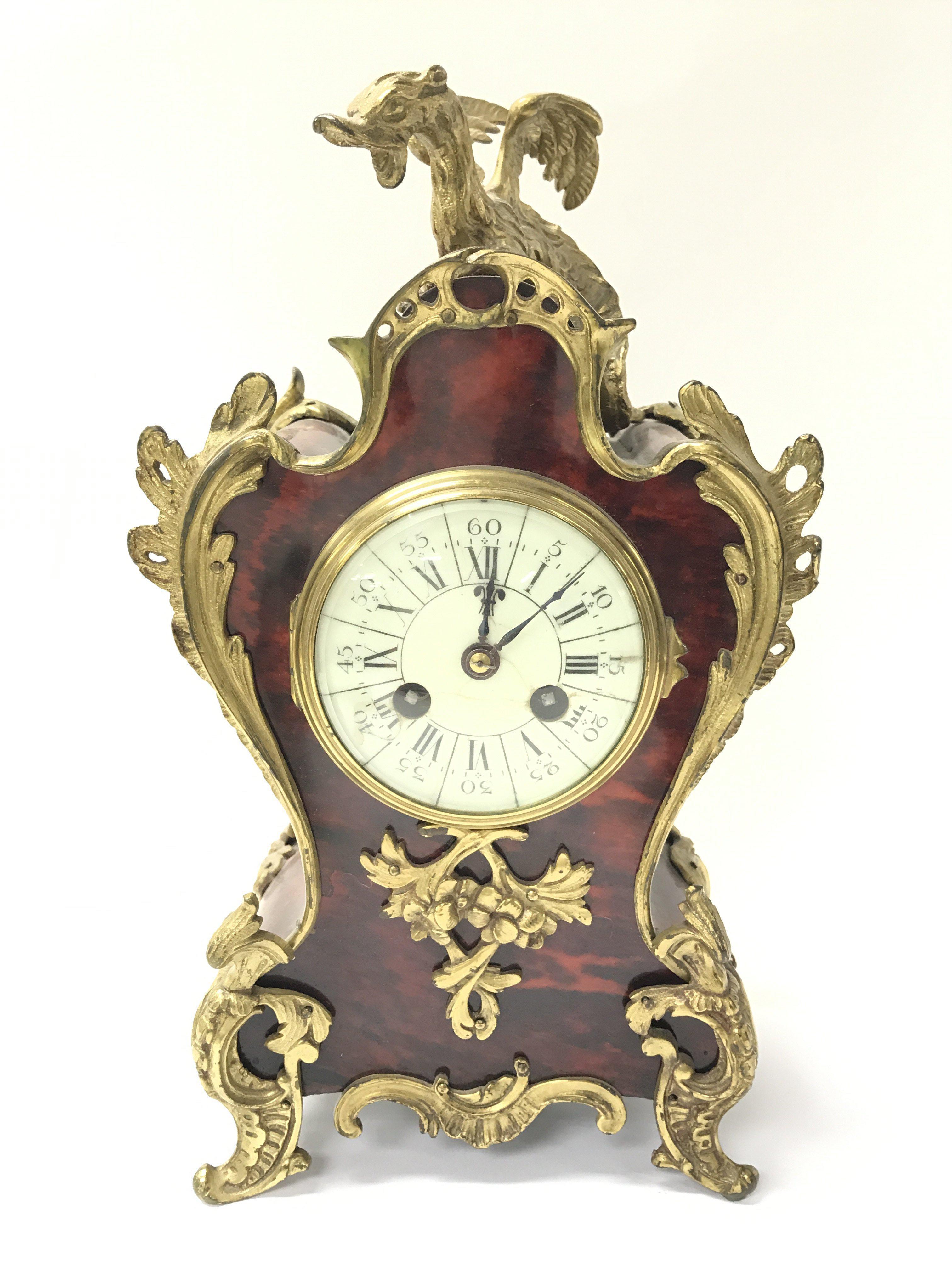 A French ornately decorated mantel clock with simu