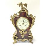 A French ornately decorated mantel clock with simu