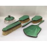 A silver and green enamel dressing table set.