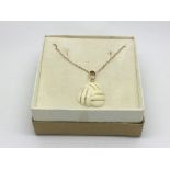 A 14ct gold and ivory pendant on a 9ct gold chain, approx