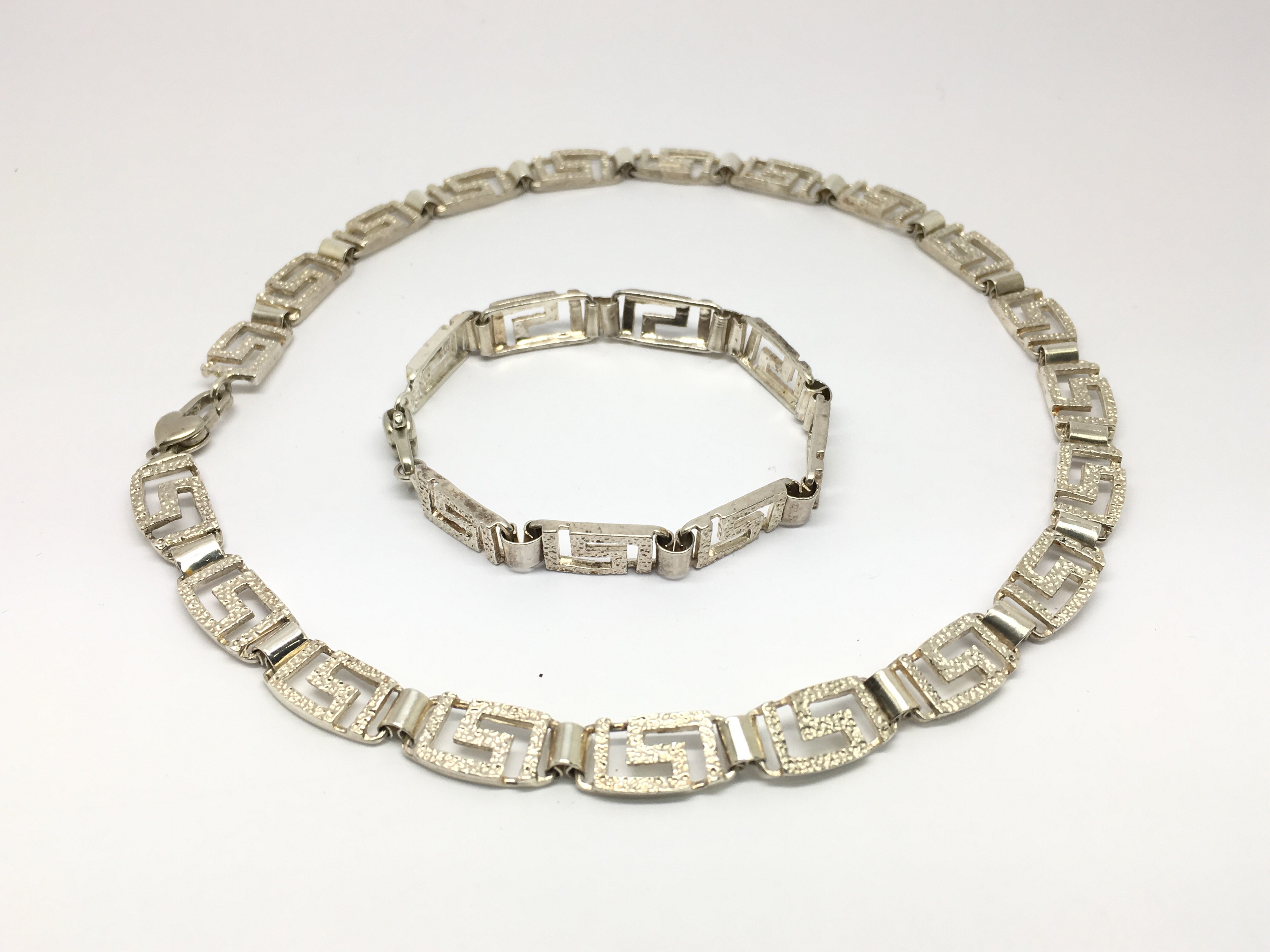 A silver necklace with conforming bracelet.