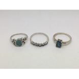 Three silver rings set with coloured stones.