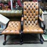 A brown leather button down open arm chair with a