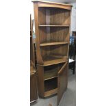 An Ercol corner display cabinet with cupboard base