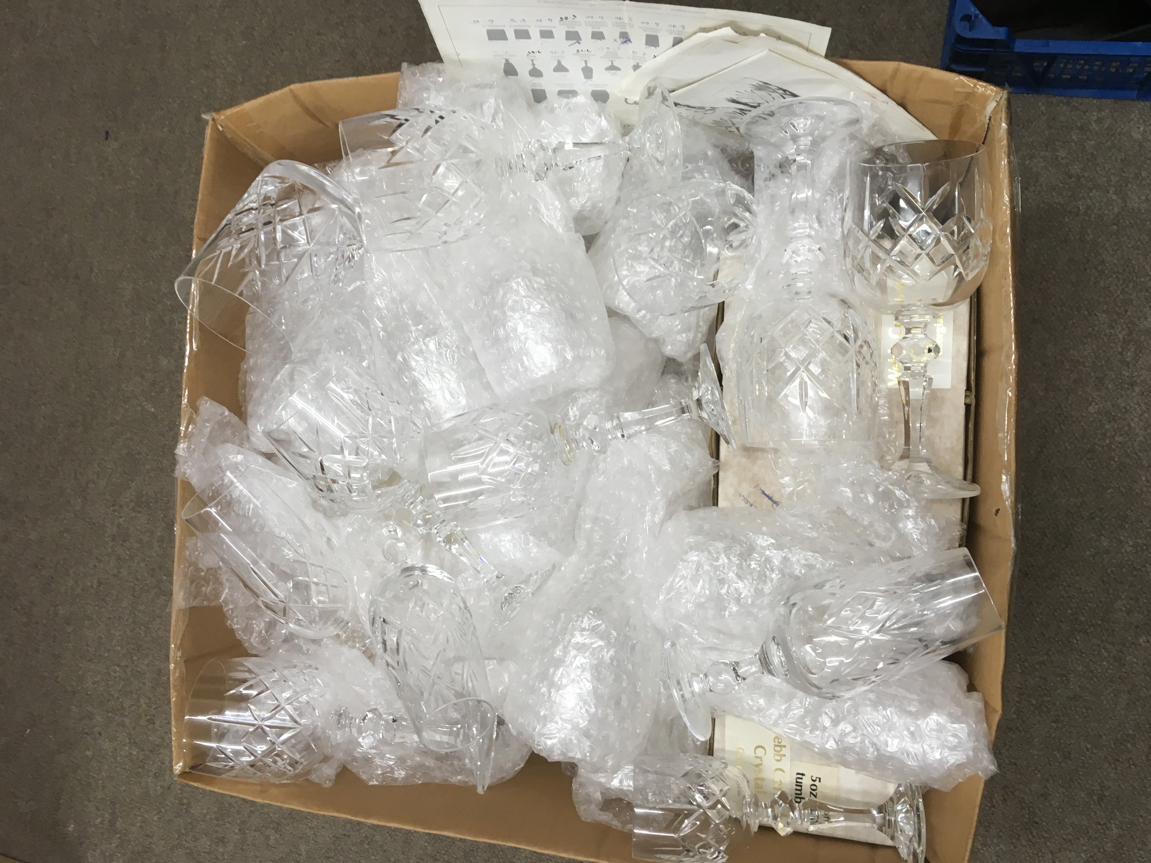 A box of loose and boxed crystal glasses.