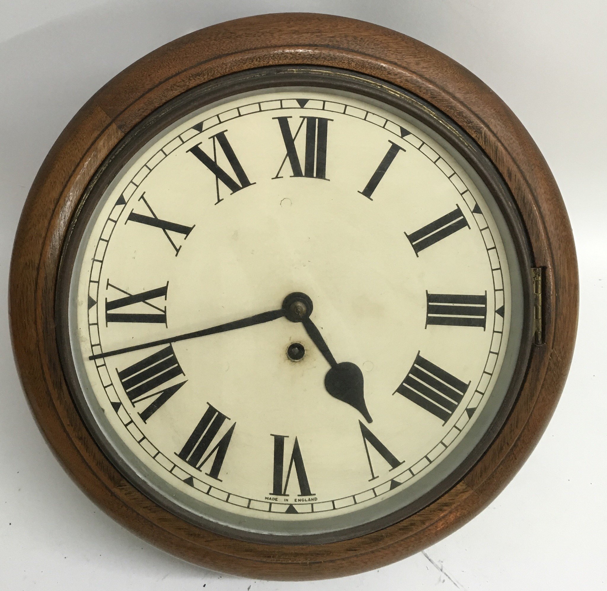 An oak station wall clock with Roman Numeral dial