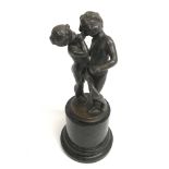 A pewter type model of a young boy and girl in con