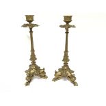 A pair of gilt metal ornate candle sticks with sty