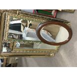 A collection of modern gilt wall mirrors and an Edwardian inlaid oval wall mirror, and a modern wall