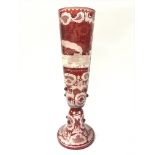 A bohemian red glass vase etched with traditional