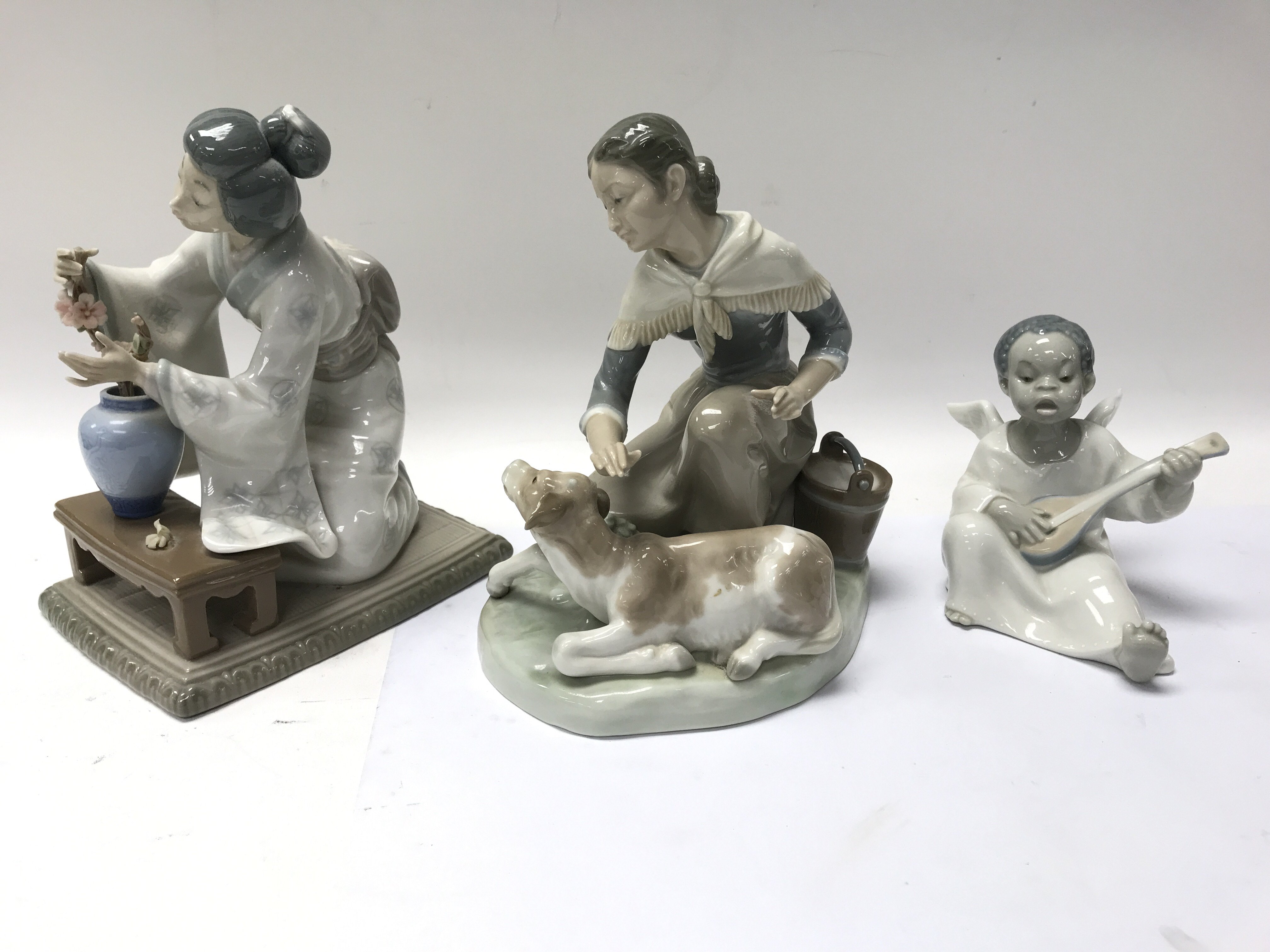 Three Lladro figures including a cherub playing a