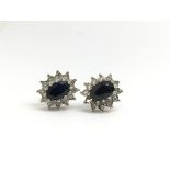 A pair of sapphire and diamond stud earrings on wh