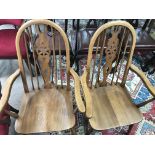 Two ecole style wheel back open arm chairs the solid seat on turned legs