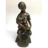 A contemporary cast metal figure of a woman holdin