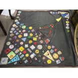 A scout's camping blanket with attached badges.