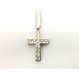 A silver cross filled with square cut stones, on a
