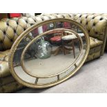 A 19th century oval neo-classical style mirror. 84