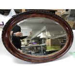 An oval bevelled edge mirror. Size approx 86x62cm